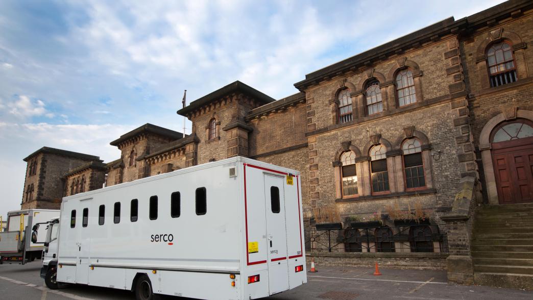 The exterior of Wandsworth prison with a white secure van parked outside.