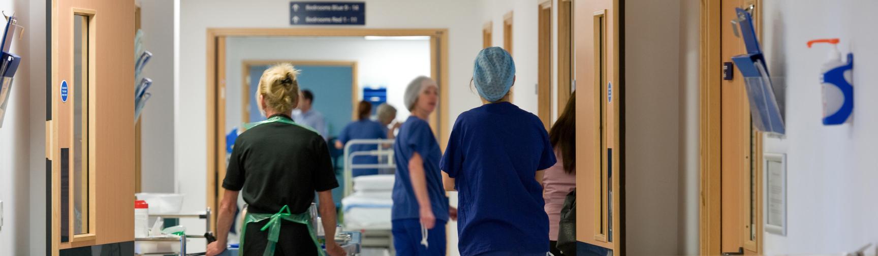 Staff walking down an NHS hospital corridor.